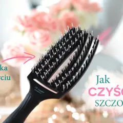 Czarna szczotka do włosów, czysta po umyciu, z różowymi kwiatami w tle. Dowiedz się, jak czyścić szczotki, by służyły dłużej.