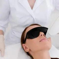Kobieta w okularach ochronnych przechodzi zabieg depilacji laserowej. Czy warto? To pytanie zadaje sobie wiele osób.