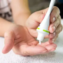 Dłoń aplikuje krem z tubki. Zastanawiasz się, co warto kupić w Hiszpanii? Kosmetyki z apteki to świetny wybór!