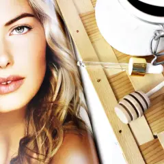 Odkryj, czym posmarować pryszcza! Na zdjęciu twarz modelki i akcesoria do pielęgnacji: pipetka z serum, miodek i buteleczka.