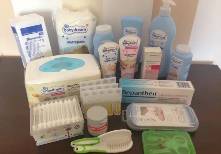 Zestaw kosmetyków dla noworodka: chusteczki, kremy, puder, płatki kosmetyczne, aspirator, grzebyk, nożyczki.
