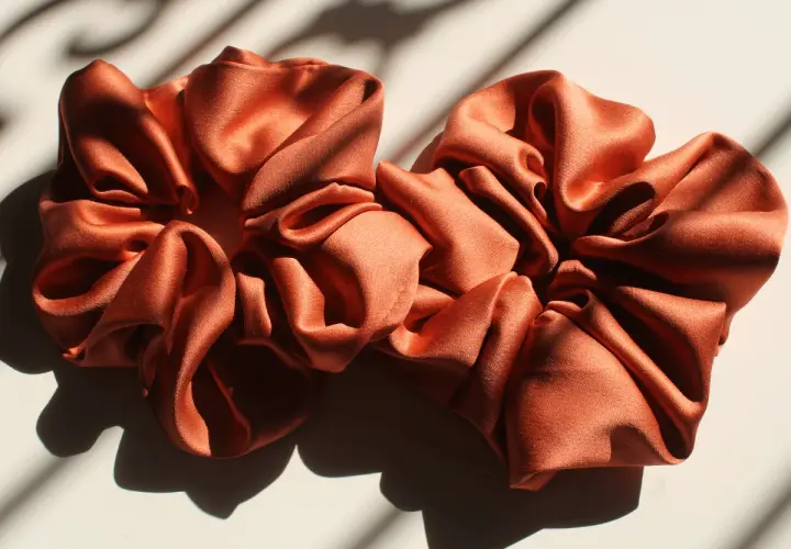 Dwie satynowe, pomarańczowe gumki do włosów. Dowiedz się, jak uszyć gumkę do włosów i stwórz własną!