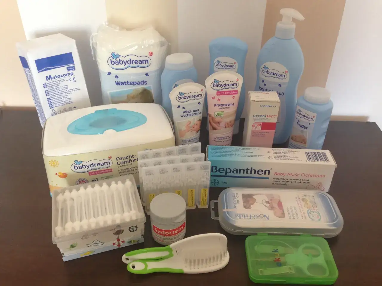Zestaw kosmetyk&oacute;w dla noworodka: chusteczki, kremy, puder, płatki kosmetyczne, aspirator, grzebyk, nożyczki.